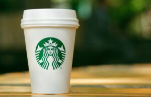 Starbucks renova programa de recompensas – por que está recebendo reação imediata Tall Starbucks to go cup on wooden table