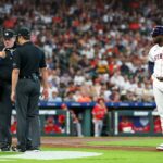 O técnico do Houston Astros, Joe Espada, discute com o árbitro da home plate, Chris Conroy, enquanto o rebatedor designado Yordan Alvarez observa.