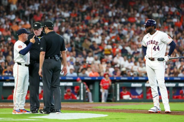 O técnico do Houston Astros, Joe Espada, discute com o árbitro da home plate, Chris Conroy, enquanto o rebatedor designado Yordan Alvarez observa.