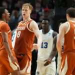 Dailyn Swain, Matas Vokietaitis e outro jogador do Texas Longhorns comemorando durante um jogo de basquete contra os BYU Cougars.