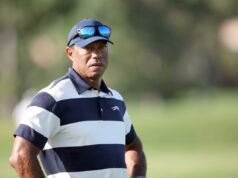 Tiger Woods envolvido em acidente de carro capotado na Flórida Tiger Woods em uma camisa pólo listrada de azul e branco e boné azul com óculos escuros.