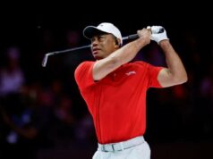 Tiger Woods jogará a final do TGL pela primeira ação de golfe ao vivo em mais de um ano, enquanto a decisão do Masters se aproxima Tiger Woods com camisa vermelha e chapéu branco, balançando um taco de golfe.