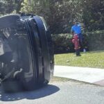 O jogador de golfe Tiger Woods fica ao lado de seu veículo capotado na Ilha de Júpiter.