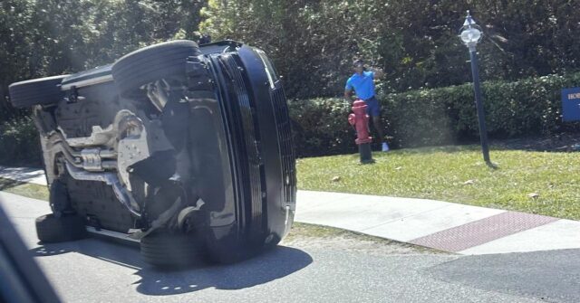 O jogador de golfe Tiger Woods fica ao lado de seu veículo capotado na Ilha de Júpiter.