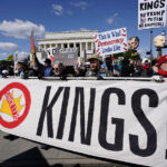 NOTA EDS: NUDEZ – Manifestantes marcham perto da Ponte Memorial durante o protesto No Kings em Washington, sábado, 28 de março de 2026. (AP Photo/Jose Luis Magana)