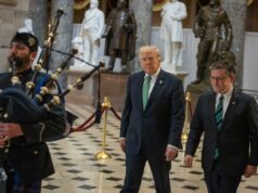 Trump considera encerrar a recessão de duas semanas do Congresso para uma rara sessão especial para encerrar a paralisação do DHS O presidente Donald Trump e o presidente da Câmara, Mike Johnson, caminhando por um corredor com um tocador de gaita de foles.