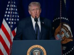 Trump diz ao regime iraniano para se render ou enfrentará “morte certa” em novo vídeo após ataques Donald Trump falando em um pódio com bandeiras dos EUA ao fundo.