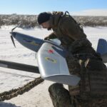 Uma moradora remove vidros quebrados de janelas de seu apartamento danificado por um ataque de drone russo na quinta-feira, em meio ao ataque da Rússia à Ucrânia, em Kharkiv, Ucrânia, 26 de fevereiro de 2026. REUTERS/Vyacheslav Madiyevskyy TPX IMAGENS DO DIA