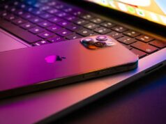 Um conjunto de ferramentas governamentais de hacking direcionadas a iPhones agora está sendo usado por cibercriminosos MacBook pro 2021 half open with Iphone 13 lit by retina display