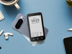 Usei um ‘sidephone’ minimalista para corrigir meu tempo de tela, mas é um luxo que a maioria não pode pagar Mão segurando um Mudita Kompakt, apresentando um close de seu botão lateral físico e ícones de segurança flutuantes.