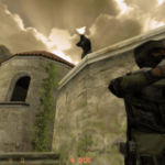 A Valve resiste a ações judiciais alegando que as loot boxes violam as leis de jogos de azar. Captura de tela do Counter-Strike mostrando dois personagens antiterroristas mascarados com rifles em um telhado e parede de pedra, com um céu nublado dramático ao fundo.