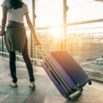 Vista traseira de uma turista asiática com mochila e chapéu andando na Khao San Road em Bangkok, Tailândia.