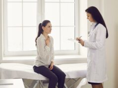 Vírus altamente contagioso sem tratamento está tomando conta da Costa Oeste Uma jovem com uma longa trança e um suéter cinza tosse em sua mão.