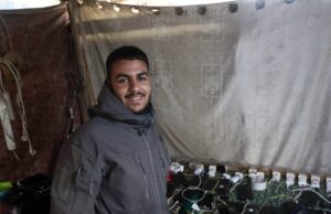 Viver no escuro: a luta de Gaza pela electricidade Abdel Karim Salman dirige-se diariamente à estação de carregamento para carregar o seu telefone e o telefone da sua esposa, que eles usam como fonte de luz na sua tenda durante toda a noite (Abdelhakim Abu Riash/Al Jazeera)