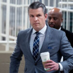 Pessoas assistem de um telhado enquanto uma nuvem de fumaça sobe após um ataque em Teerã, Irã, domingo, 1º de março de 2026. (AP Photo/Vahid Salemi)