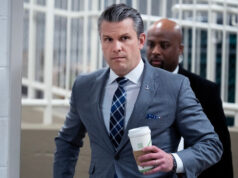 Você é um americano preso em uma zona de guerra? Chupe, diz o Pentágono. Pessoas assistem de um telhado enquanto uma nuvem de fumaça sobe após um ataque em Teerã, Irã, domingo, 1º de março de 2026. (AP Photo/Vahid Salemi)