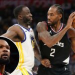 Kawhi Leonard nº 2 do LA Clippers segura a bola enquanto é defendido por Draymond Green nº 23 do Golden State Warriors.