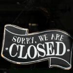 A closed sign in the window of a small business