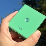 Motorola Razr 2025 cercado por contas verdes à luz do sol