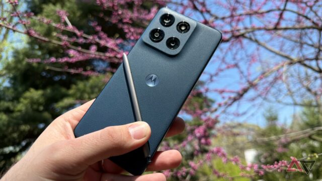 Dois telefones Motorola Razr ao lado de um Samsung Galaxy Z Flip sujo, cercado por coroas douradas flutuantes em um fundo azul claro.