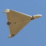Drone Shahed-136 'Kamikaze' de fabricação iraniana voando sobre um céu azul.
