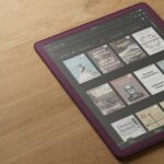 Modo escuro em um Kindle colorido segurado na mão.