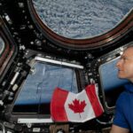 Quatro pessoas se abraçam dentro de uma cápsula espacial