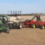 A concessionária de máquinas está transportando grandes armas para a colheita comunitária de uma cidade