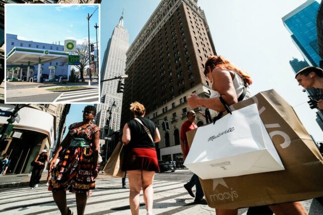 Uma mulher passa pela vitrine de uma loja de varejo com cinco manequins.