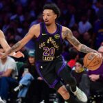 O jogador do Los Angeles Lakers, Jalen Hood-Schifino, segura uma bola de basquete se preparando para arremessar.