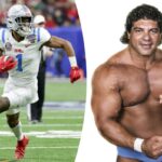 O lutador Superstar Billy Graham aponta para frente enquanto flexiona.