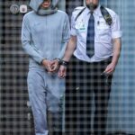 Al-Danasurt sorri ao ser conduzido à van da prisão após o julgamento na quarta-feira