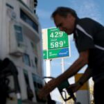 Carlos Ferre reabastecendo seu veículo em um posto de gasolina onde a gasolina normal custa US$ 4,29 por galão e o diesel custa US$ 5,89 por galão.