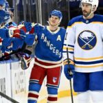 O defensor do Rangers, Adam Fox (23), patina com o disco.