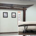 Espada de samurai histórica com bainha marrom escura apoiada em um suporte preto.