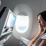 Woman watching a video screen on a plane.
