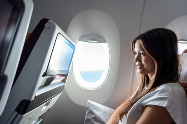 Woman watching a video screen on a plane.