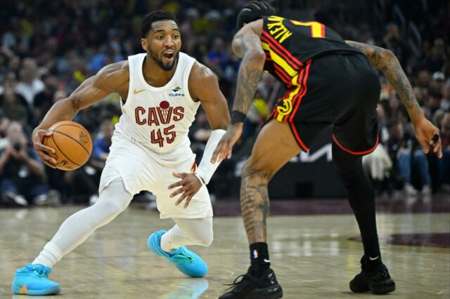 O armador do Cleveland Cavaliers, Donovan Mitchell, dribla a bola enquanto o armador do Atlanta Hawks, Nickeil Alexander-Walker, defende.