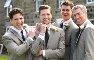 A regra da gravata da noiva para todos os convidados do casamento do sexo masculino gera uma grande rivalidade familiar: ‘Não estaremos lá’ Quatro homens felizes, incluindo um noivo, padrinho e dois padrinhos, sorrindo para a câmera ao ar livre.
