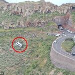 Uma vista aérea mostra o local da queda de um ônibus turístico que saiu da estrada