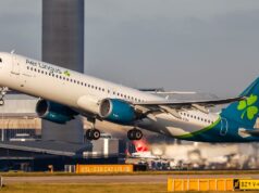 Aer Lingus cancela alguns voos do horário de verão Mark Tighe falando. Ele está do lado de fora e veste um blazer cinza e uma camisa listrada branca e cinza. Ele tem cabelos grisalhos e barba.