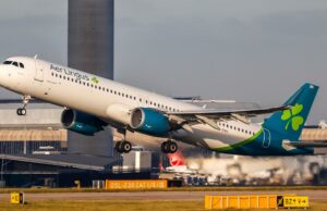 Aer Lingus cancela alguns voos do horário de verão Mark Tighe falando. Ele está do lado de fora e veste um blazer cinza e uma camisa listrada branca e cinza. Ele tem cabelos grisalhos e barba.
