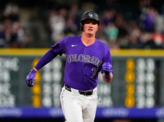 Alvos de isenção de beisebol de fantasia para poder, roubos e ajuda do apanhador O jogador de beisebol Carter Jensen em uniforme branco com detalhes em roxo e azul, usando um capacete bicolor roxo e azul.