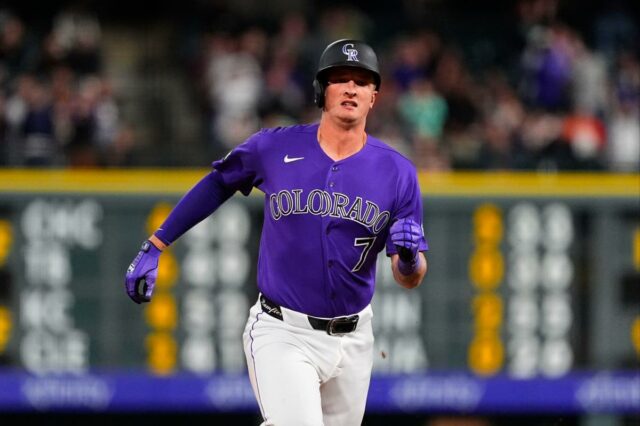 O jogador de beisebol Carter Jensen em uniforme branco com detalhes em roxo e azul, usando um capacete bicolor roxo e azul.