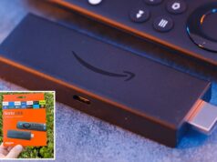 Amazon processada por supostamente sabotar Fire TV Sticks para forçar os usuários a atualizar Mão segurando uma embalagem laranja do dispositivo de streaming Amazon Fire TV Stick contra um fundo de folhagem verde.