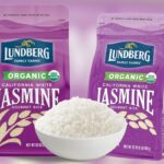 Dois sacos roxos de arroz de jasmim branco Lundberg Organic California e uma tigela de arroz branco.
