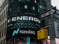 As ações da X-energy disparam 27% no primeiro dia de negociação após IPO aumentado X-energy appears on a sign above the Nasdaq.