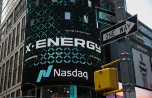 As ações da X-energy disparam 27% no primeiro dia de negociação após IPO aumentado X-energy appears on a sign above the Nasdaq.