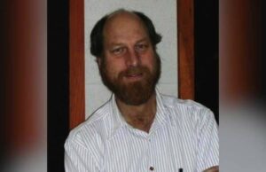 Assassinato de cientista nascido em Calgary está ligado a misteriosas mortes e desaparecimentos nos EUA, apesar da rápida prisão Um homem de meia-idade, barbeado, de terno e gravata, fala atrás de um microfone.