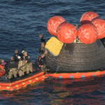 Comandante Reid Wiseman, apontando para os adesivos da espaçonave Orion